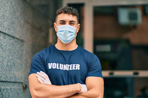 Alt Text: A young medical volunteer looks into camera